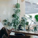 Vrouw zit achter laptop in cafe