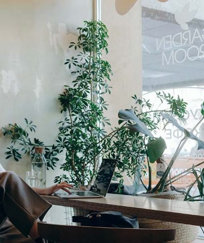 Vrouw zit achter laptop in cafe